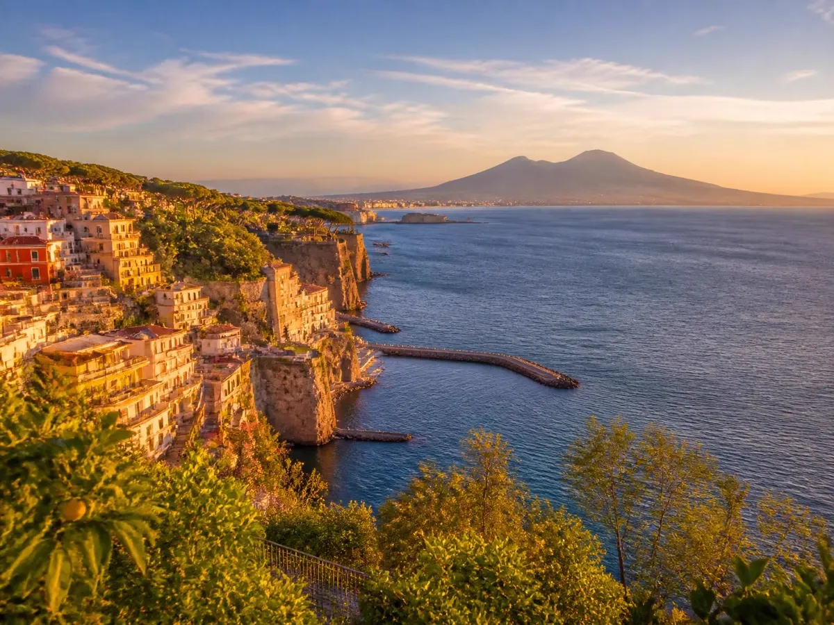 Sorrento arroccata sulle scogliere di tufo affacciate sul Golfo di Napoli, con il Vesuvio all'orizzonte