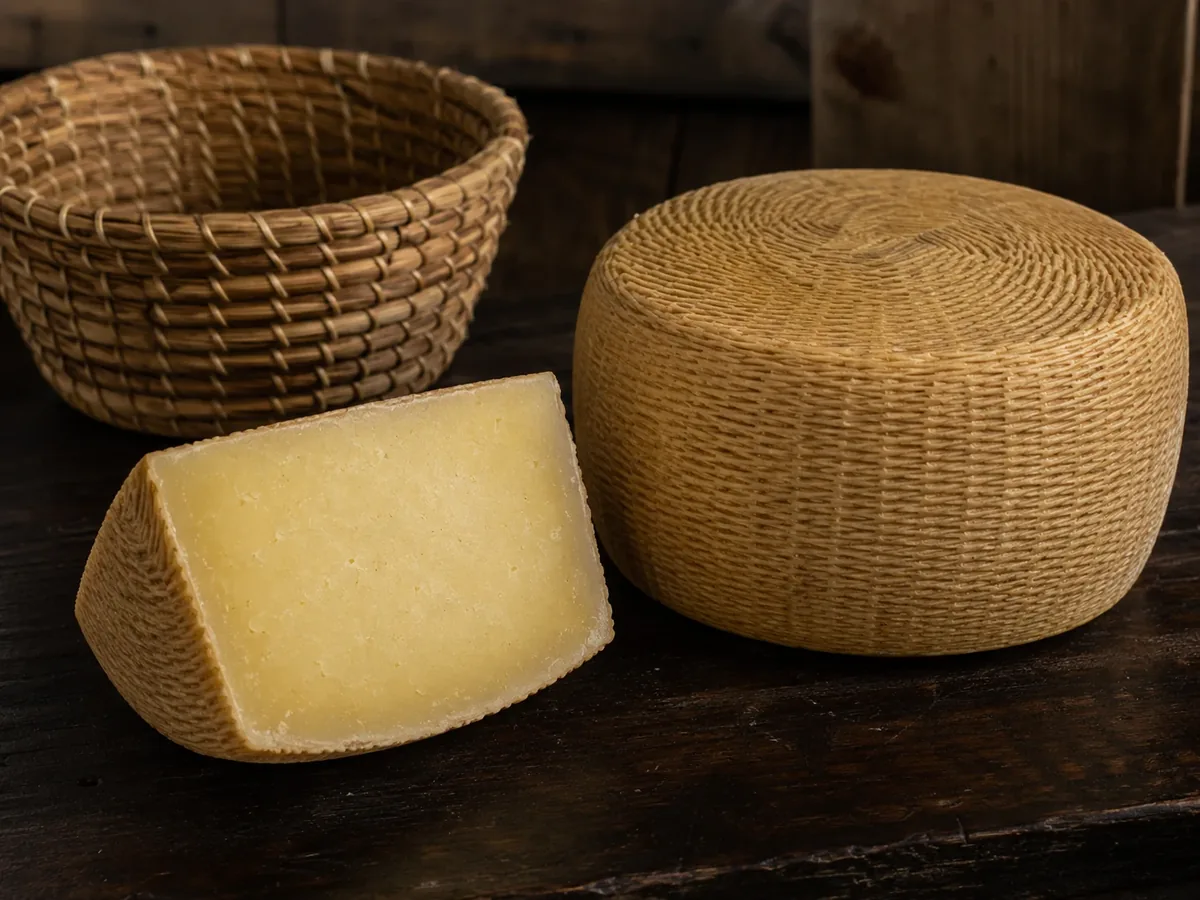 Forma di Canestrato Pugliese DOP su tavolo di legno