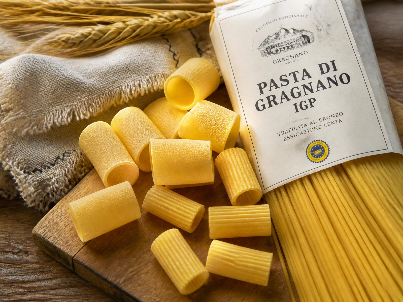 Pasta di Gragnano IGP trafilata al bronzo: paccheri, rigatoni e spaghetti su tagliere di legno